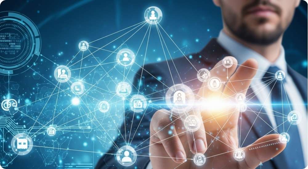 A businessman in a suit interacts with a futuristic blue digital interface displaying a network of connected people icons and data visualizations, symbolizing technology, global connectivity, and strategic human resource management in emerging markets.