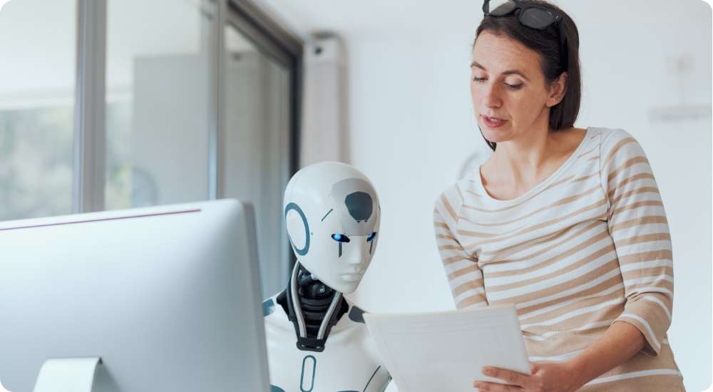 A professional woman in an office setting collaborates with a white humanoid robot, reviewing documents together, symbolizing the integration of human judgment in AI-powered recruitment processes.