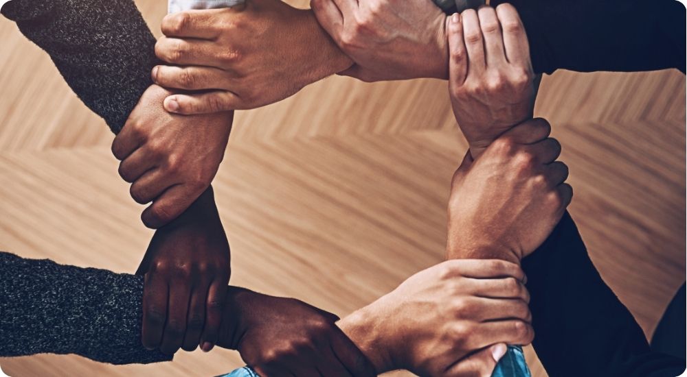 Solidarity, holding or hands of business people with diversity for group support or teamwork in office. Community, link or above group of employees with mission or team building for startup goals together