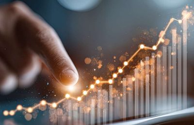 A close-up shot of a person using their finger to interact with an upward-trending digital business growth graph displayed on a tablet screen.