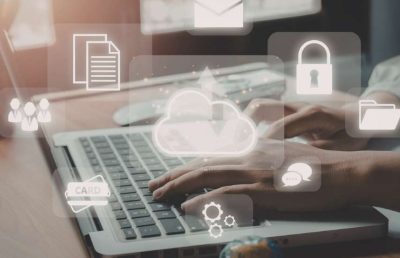 A person's hands typing on a laptop keyboard, overlaid with digital icons representing cloud computing, data security, team collaboration, and financial operations.