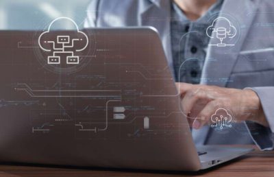 A professional works on a laptop with futuristic data and cloud computing icons overlaid on the screen, illustrating the concepts of long-term technology vision and recruitment strategies.