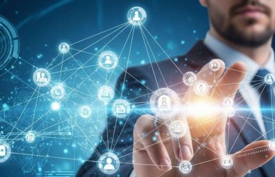 A businessman in a suit interacts with a futuristic blue digital interface displaying a network of connected people icons and data visualizations, symbolizing technology, global connectivity, and strategic human resource management in emerging markets.